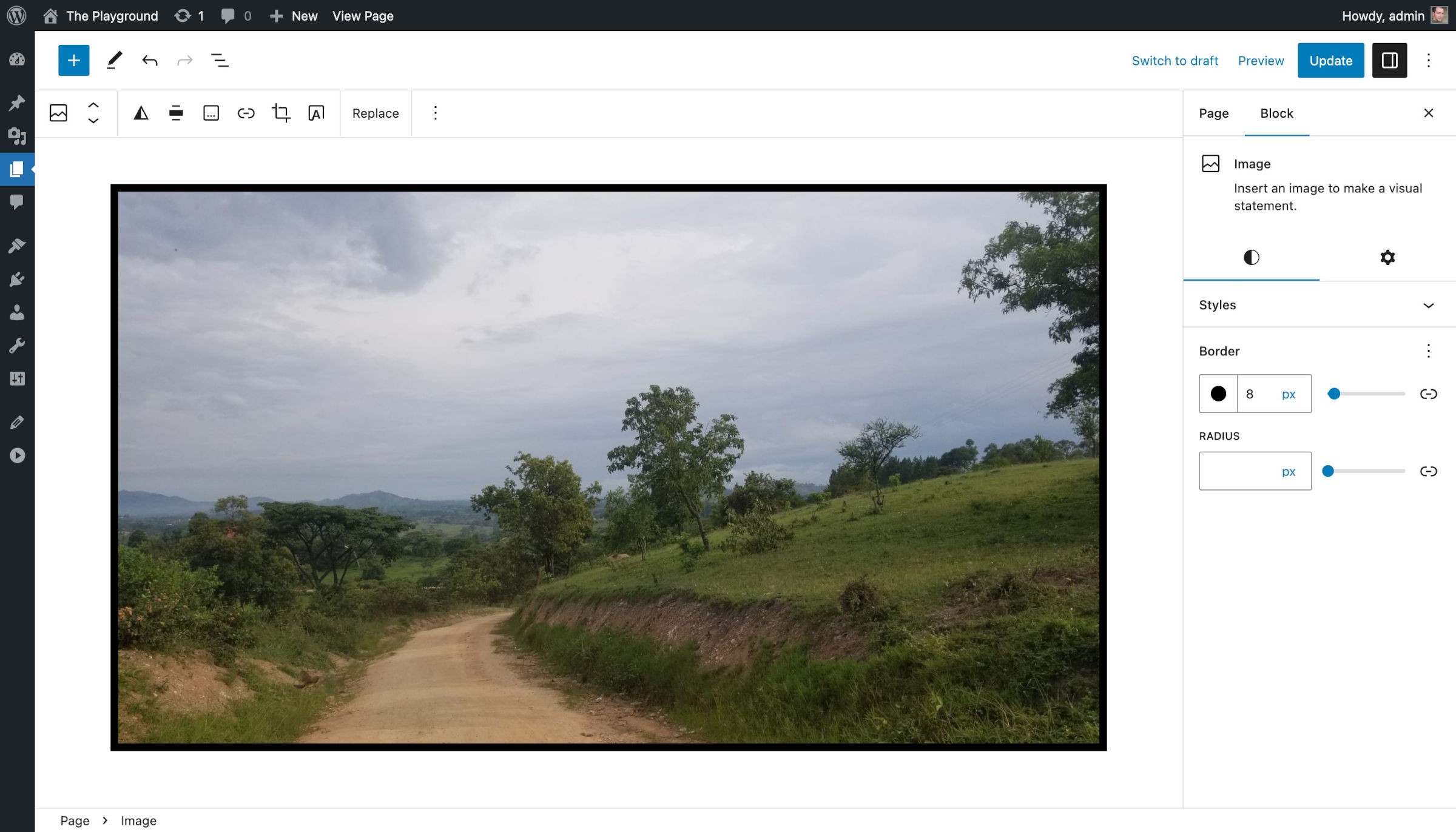 WordPress 文章编辑器，内容画布中显示了一张乡村土路的图片。它周围有一个黑色边框。