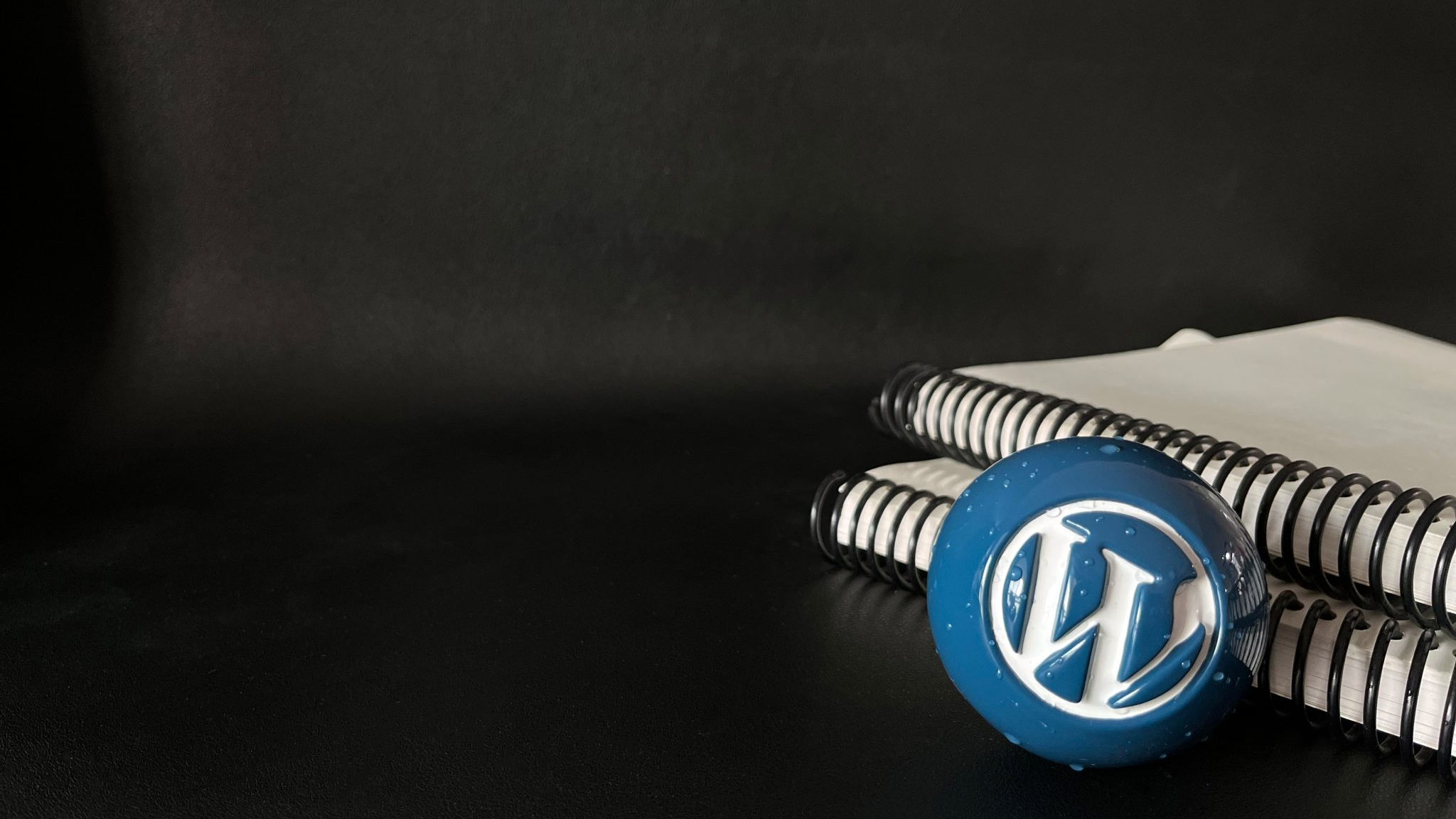 WordPress 蓝色球体壁纸系列：球体和笔记本，可在 WordPress 照片目录中找到。